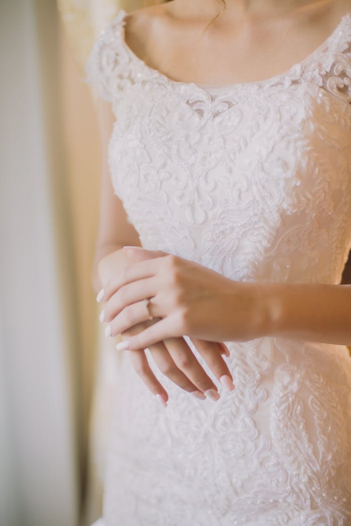 Close-up of a bride's hands in lace dress highlighting elegance and style.